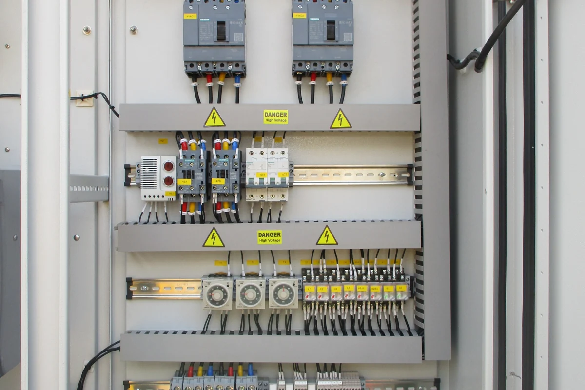 Outdoor distribution board interior showing moulded-case breakers and segregated feeder wiring